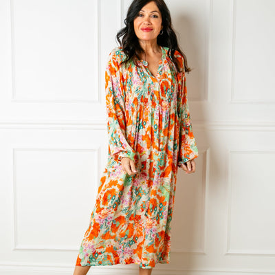 The orange Wild Garden Maxi Dress with long balloon sleeves and a collarless v neckline